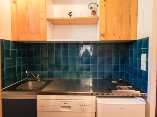 - une cuisine avec des murs carrelés verts et un évier dans l'établissement Appartement chaleureux à 300m des pistes, 5 personnes, balcon, draps, parking - FR-1-508-228, à Lanslebourg-Mont-Cenis