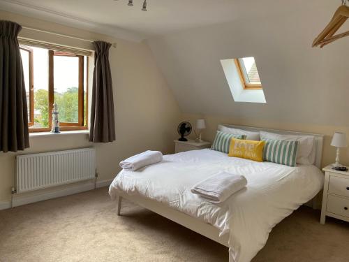 um quarto com uma cama branca e uma janela em Stylish contemporary seaside holiday home with 5 bedrooms, sea view, parking and EV point em Kent