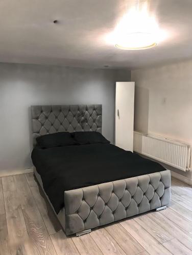 a bedroom with a large bed with a large headboard at 1 Bedroom Apartment by London Stratford in London