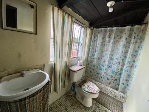 y baño con lavabo, aseo y bañera. en El Calvario Hostal en Cobán