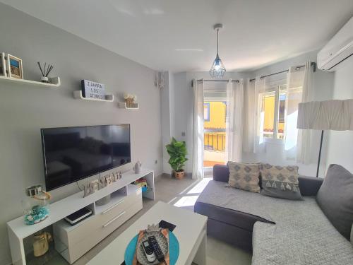 a living room with a blue couch and a tv at Apartamento Luna de Zahara - Situado en la zona tranquila del pueblo a 3 min de la playa y ocio in Zahara de los Atunes