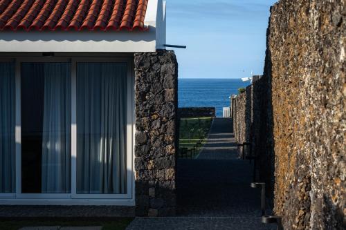 uma vista para o oceano a partir do exterior de um edifício em ENTRE MUROS - Turismo Rural - Casa com jardim e acesso direto ao mar em Ribeira Grande