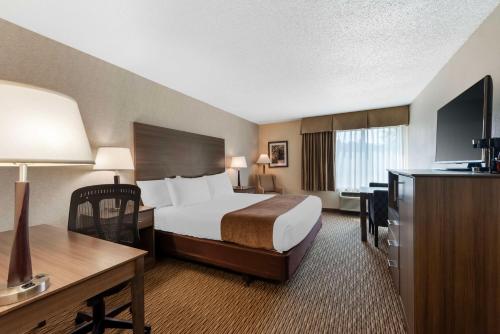 a hotel room with a bed and a desk at Best Western Spooner Riverplace in Shell Lake