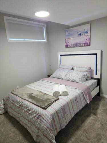 1 dormitorio con 1 cama con 2 toallas en Cozy entire suite!, en Calgary