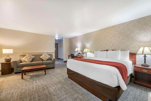 a hotel room with a large bed and a couch at SureStay Plus Hotel by Best Western Buffalo in Buffalo