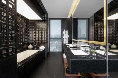 a bathroom with two sinks and a large window at The Temple House in Chengdu