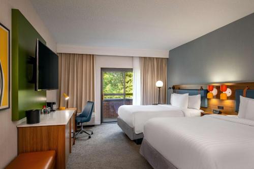 um quarto de hotel com duas camas e uma televisão em Sonesta Select Boston Foxborough Mansfield em Foxborough