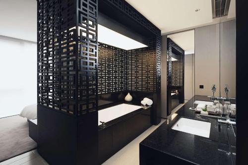 a bathroom with a sink and a large mirror at The Temple House in Chengdu