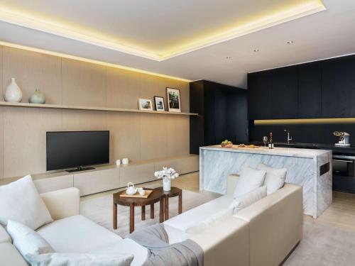 a living room with a white couch and a tv at The Temple House in Chengdu