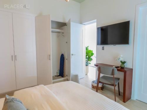 a bedroom with a bed and a desk and a tv at Hermoso apartamento 1 hab a pasos de la playa in Punta Cana