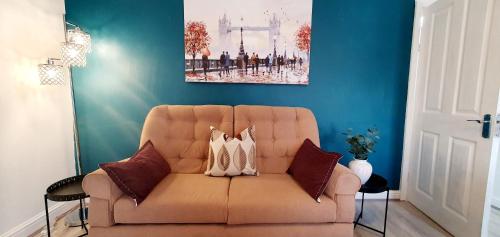 a couch in a living room with a painting on the wall at Stourbridge House, Luxurious 3 Bedrooms - Ideal Location for Contractors and Families, Free Parking, Fast Wifi, Sleeps up to 8 in Lye