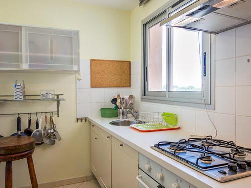 Il comprend une cuisine équipée d'une cuisinière et d'un évier. dans l'établissement Bel appartement spacieux face à l'étang - 2 chambres, parking, pas de WIFI - FR-1-604-5, à Mèze