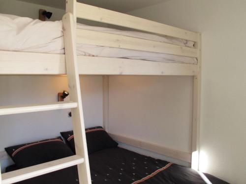 Ce lit superposé se trouve dans un dortoir avec une échelle. dans l'établissement Appartement Montagne Contemporain, Rénové avec Accès Direct aux Pistes - FR-1-634-46, à Avoriaz