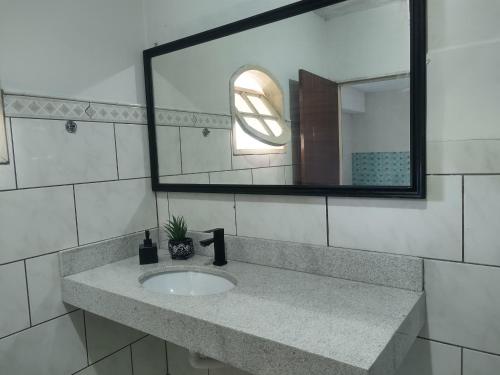 a bathroom with a sink and a mirror at Casa Espaço Pérola in Rio das Ostras