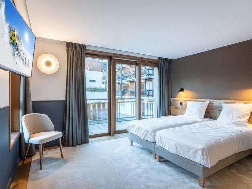 a hotel room with a bed and a large window at Appartement Courchevel 1650, 3 pièces, 6 personnes - FR-1-618-33 in Courchevel