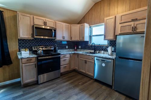 eine Küche mit Holzschränken und blauen Geräten in der Unterkunft Lazy Spring Farm 
