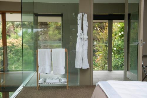 a bedroom with a glass walled shower and towels at Eagles Nest in Russell