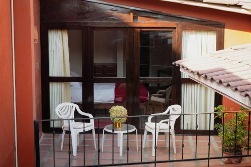 a balcony with two chairs and a table and a bed at Hotel Pilancones in Cajamarca