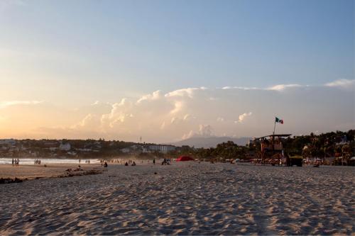 a group of people on the beach at sunset at Casa Daikiri in Puerto Escondido
