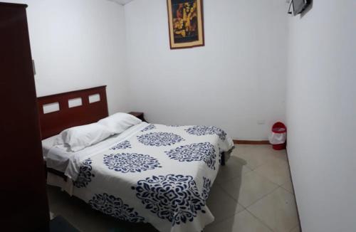 ein Schlafzimmer mit einem Bett mit einer blauen und weißen Decke in der Unterkunft Hotel Richard's in Riobamba