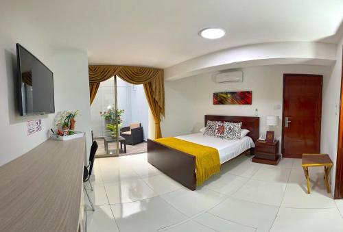 カリにあるHOTEL BOUTIQUE LUXURYの黄色い毛布付きのベッドが備わるホテルルームです。