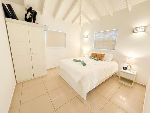 a bedroom with a white bed and a white ceiling at Villa Pearl - Steps from the Sea in Kralendijk
