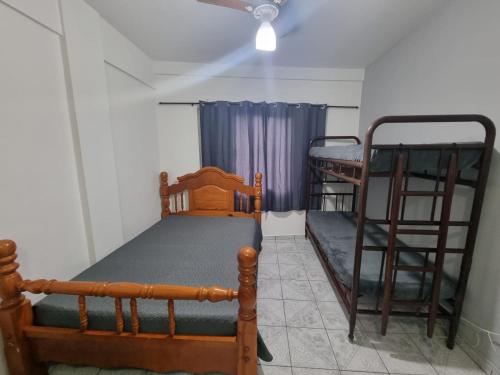 a room with two bunk beds and a ceiling fan at Kitnet Ubatuba in Ubatuba