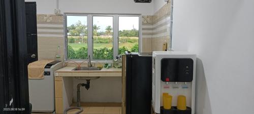a small kitchen with a sink and a refrigerator at Santai Homestay in Tuaran