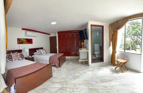a hotel room with two beds and a window at HOTEL BOUTIQUE LUXURY in Cali