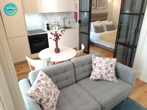 uma sala de estar com um sofá e uma mesa em Santa Catarina Patio Apartment - com possibilidade Parking no Porto