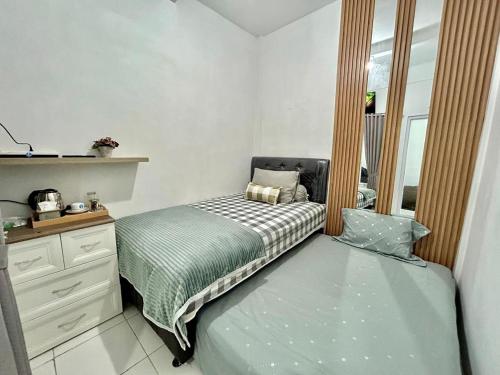 ein Schlafzimmer mit einem Bett, einer Kommode und einem Fenster in der Unterkunft Arum Bromo Villas in Ngadisari