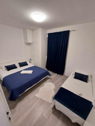 a bedroom with two beds and a blue blanket at Apartments with parking space Kraj, Pasman - 335 in Tkon