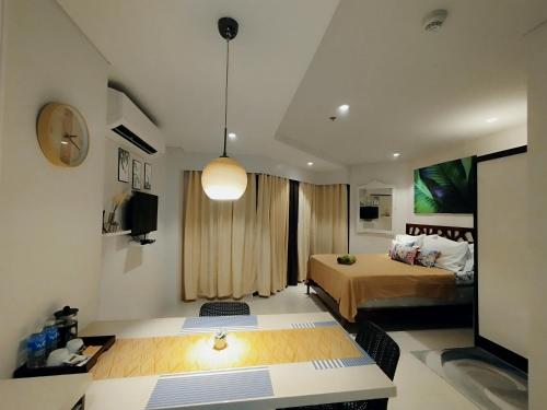 1 dormitorio con 1 cama y TV en Family Room en Maribago