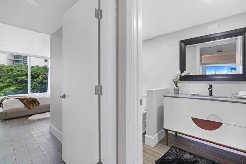a bathroom with a sink and a mirror at The Palms! Direct water view corner condo in Miami