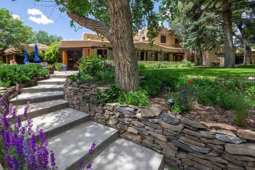 a garden with a stone wall and a tree at Inn on La Loma Plaza in Taos