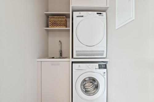 a white laundry room with a washer and dryer at City View Lux in the City Center with Free Parking in Reykjavík