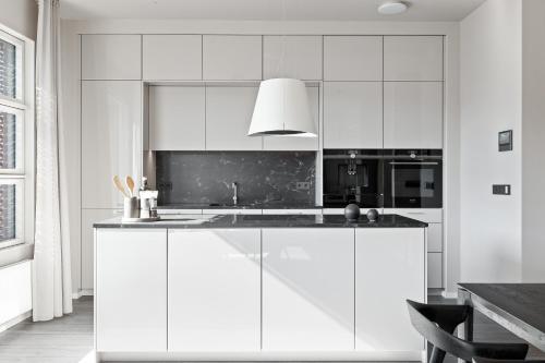 a white kitchen with white cabinets and a sink at City View Lux in the City Center with Free Parking in Reykjavík