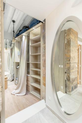 - un miroir rond dans une chambre avec des étagères dans l'établissement La Suite de Montorgueil, à Paris
