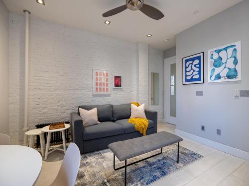 ein Wohnzimmer mit einem Sofa und einem Tisch in der Unterkunft Cozy & Convenient Midtown Apartment! in New York