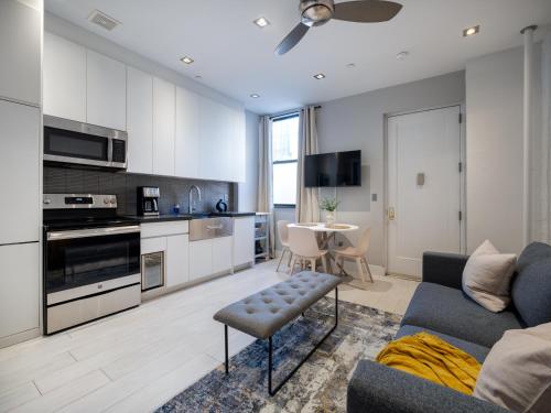 sala de estar con sofá azul y cocina en Cozy & Convenient Midtown Apartment! en Nueva York