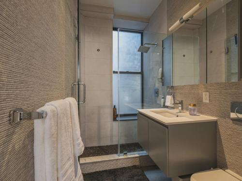 y baño con lavabo y ducha. en Cozy & Convenient Midtown Apartment! en Nueva York