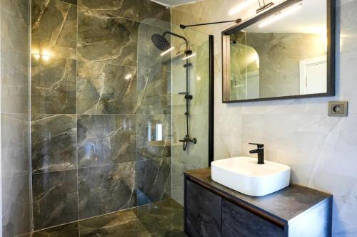 y baño con lavabo y ducha con espejo. en Dalyan Villa Alba, en Dalyan