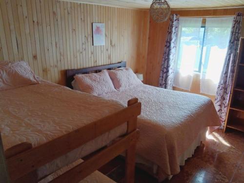 1 dormitorio con cama y ventana en Hostal Turismo Allipen en Melipeuco