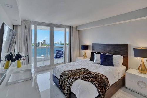 a bedroom with a large bed and a large window at A Wave From It All! Direct water views! in Miami