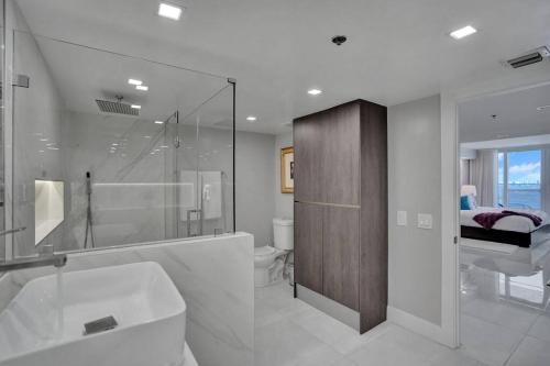 a bathroom with a tub and a sink and a toilet at A Wave From It All! Direct water views! in Miami