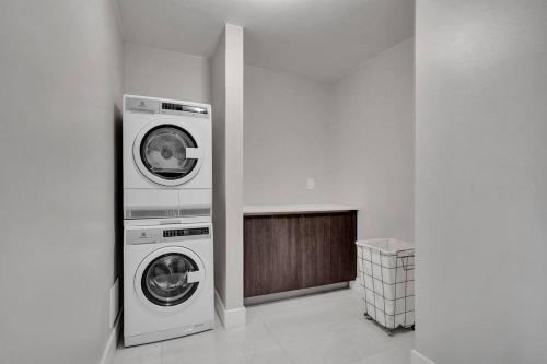 a laundry room with two washing machines in it at A Wave From It All! Direct water views! in Miami