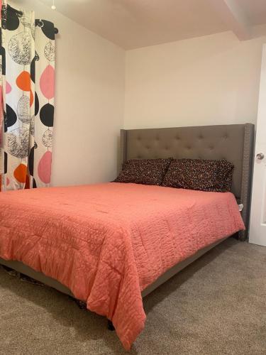 a bedroom with a bed with a red bedspread at Entire cozy home in Madera