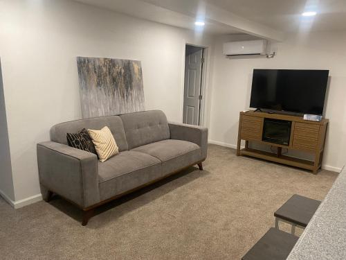 a living room with a couch and a flat screen tv at Entire cozy home in Madera