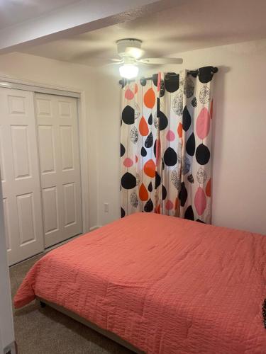 a bedroom with a bed with a red bedspread at Entire cozy home in Madera