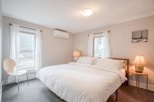 a bedroom with a white bed and two windows at Patty's Place in Coeur d'Alene